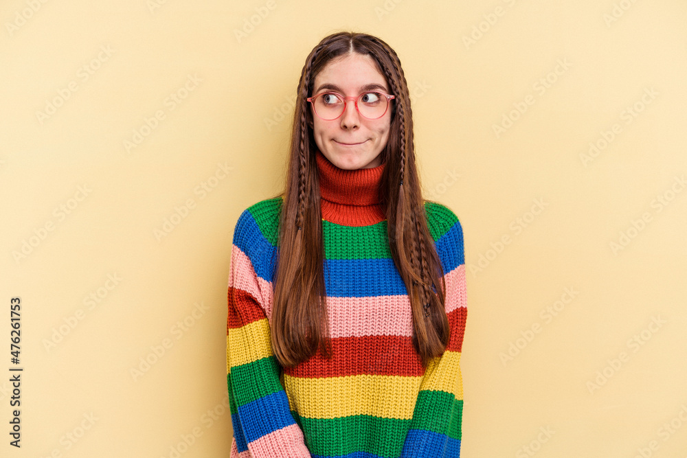 Young caucasian woman isolated on yellow background confused, feels doubtful and unsure.