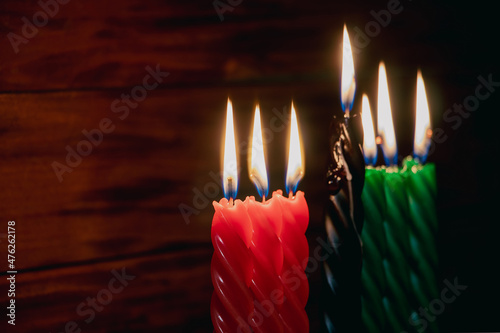 Happy Kwanzaa. African American holiday. Seven burning candles, red, black and green, in kinara candlestick. photo