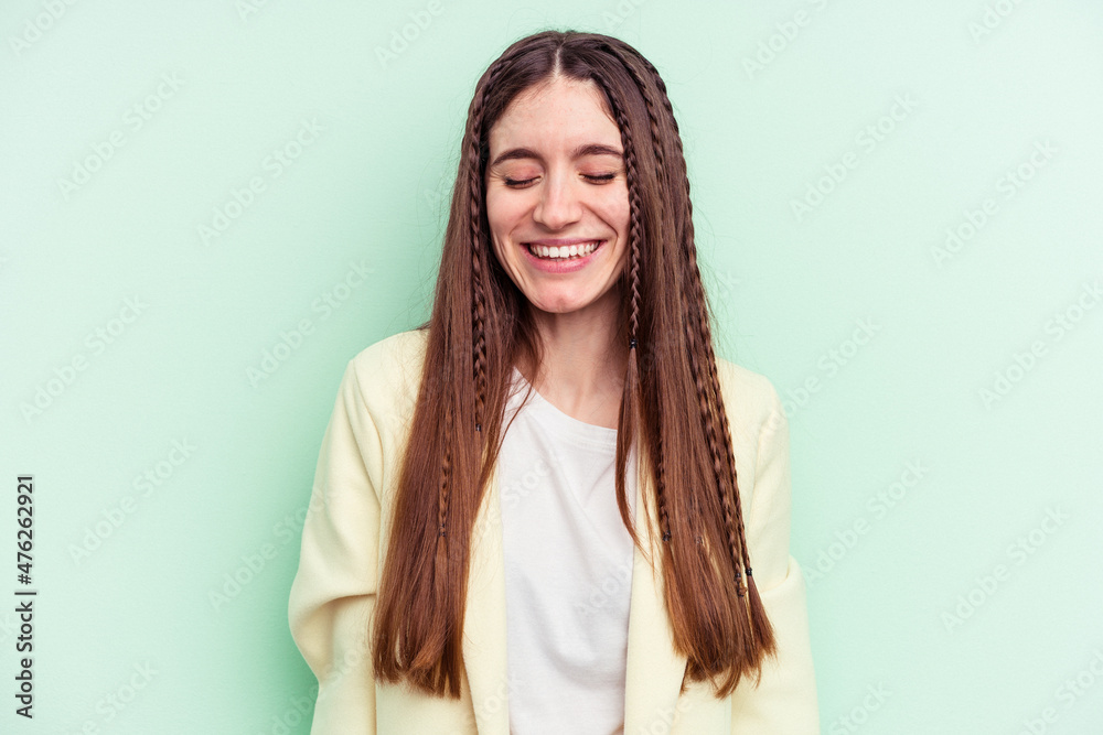 Young caucasian woman isolated on green background laughs and closes eyes, feels relaxed and happy. Young caucasian woman isolated on green background laughs and closes eyes, feels relaxed and happy.