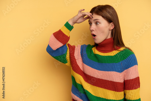 Young English woman isolated on yellow background looking far away keeping hand on forehead.