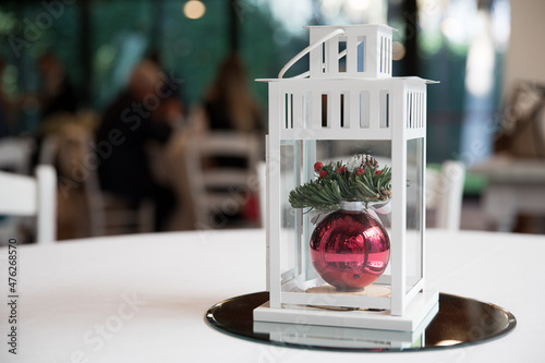 Decorazione natalizia a forma di lanterna contenente palla di natale rossa photo