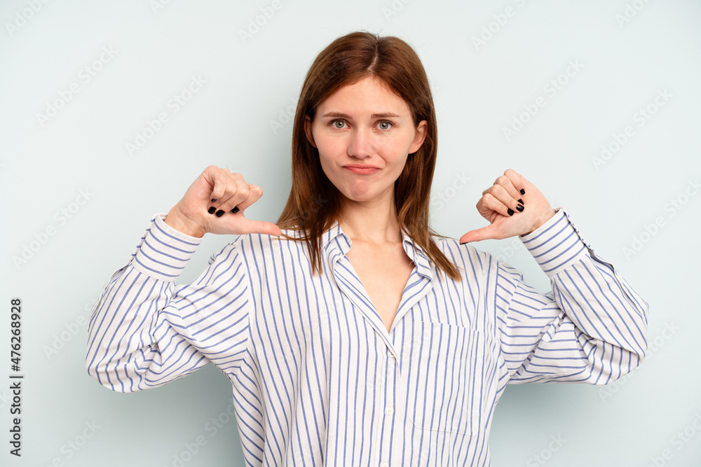 Young English woman isolated on blue background feels proud and self confident, example to follow. Young English woman isolated on blue background feels proud and self confident, example to follow.