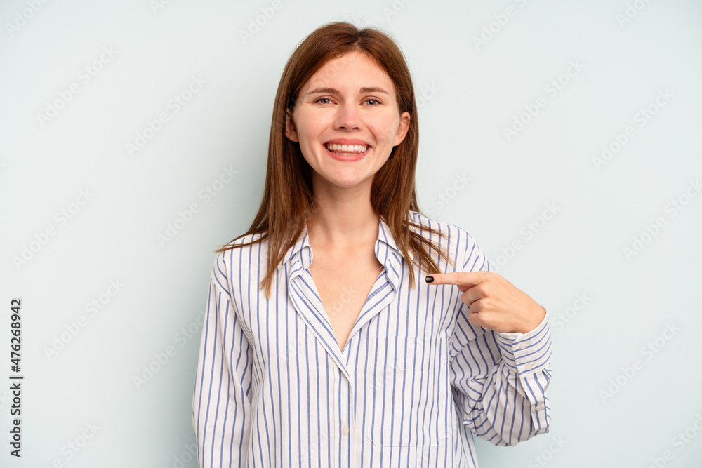 Young English woman isolated on blue background person pointing by hand to a shirt copy space, proud and confident Young English woman isolated on blue background person pointing by hand to a shirt copy space, proud and confident