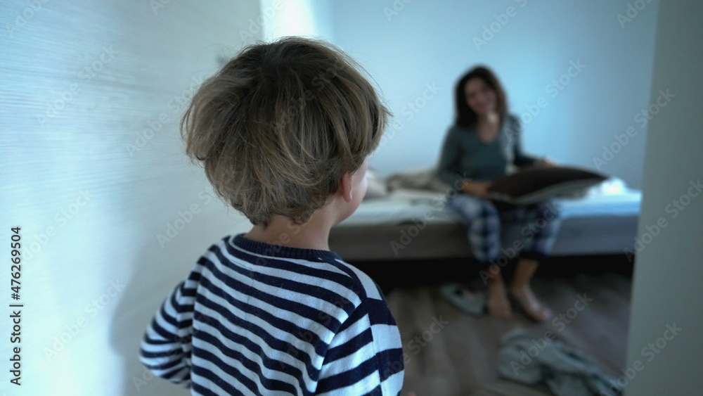Playful mother and child playing with pillow fight in morning bed, authentic real life family play Playful mother and child playing with pillow fight in morning bed, authentic real life family play