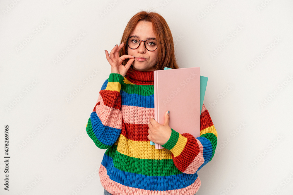 Young student caucasian woman isolated on white background with fingers on lips keeping a secret. Young student caucasian woman isolated on white background with fingers on lips keeping a secret.