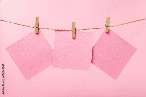 Stickers for notes on a pink background. Pink sticky notes on a string. There is room for copy space