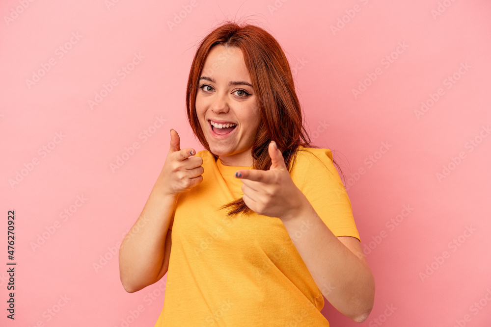 Young caucasian woman isolated on pink background cheerful smiles pointing to front. Young caucasian woman isolated on pink background cheerful smiles pointing to front.