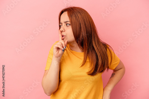 Young caucasian woman isolated on pink background keeping a secret or asking for silence.
