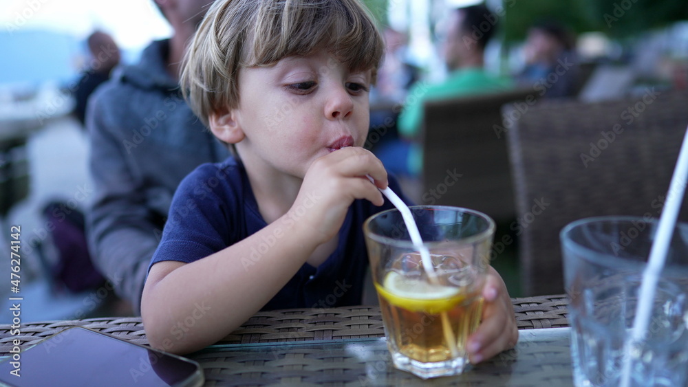 Child drinking from straw juice Child drinking from straw juice