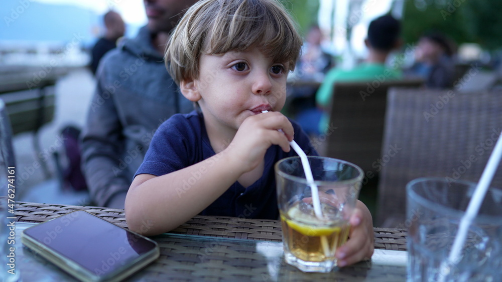 Child drinking from straw juice