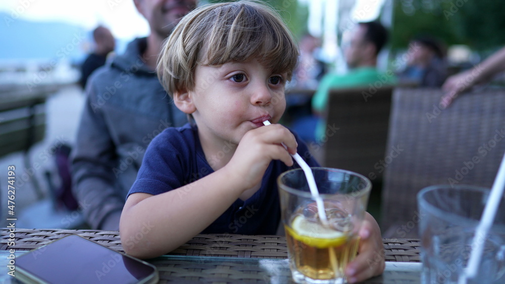 Child drinking from straw juice Child drinking from straw juice