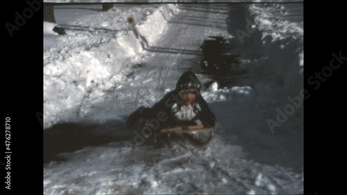 Backyard Sledding 1972 - A girl rides a sled down a hill behind her home in Vernon Township, New Jersey in 1972.