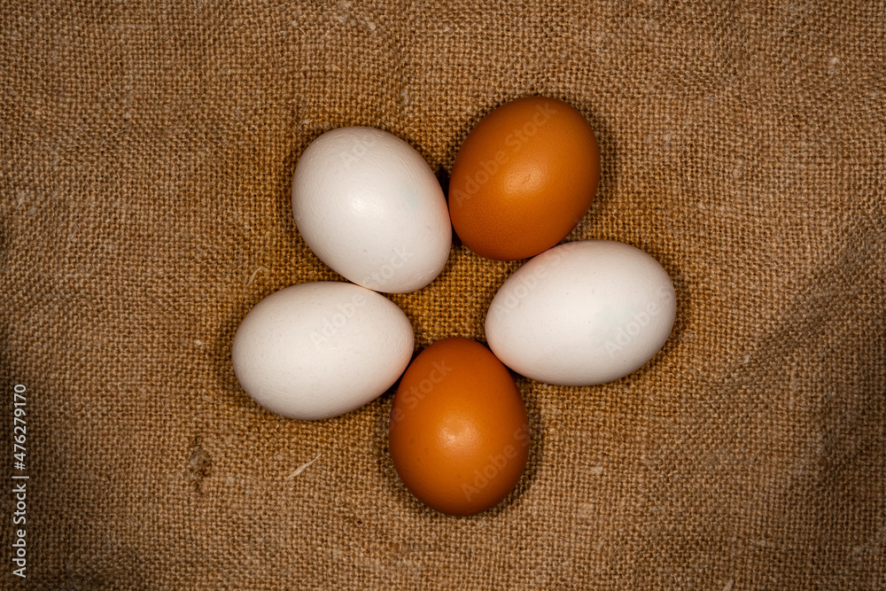 Textured, chicken eggs, of different colors, on a textured matting substrate. Farm, eco-friendly eggs, on a natural substrate. Textured, chicken eggs, of different colors, on a textured matting substrate. Farm, eco-friendly eggs, on a natural substrate.