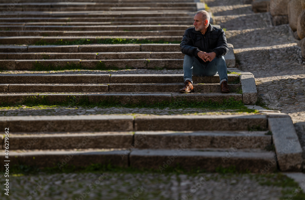 Adult man sitting on stairway. Segovia, Spain
