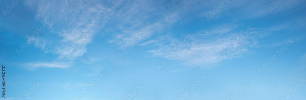 wide blue sky with fluffy cirrus clouds