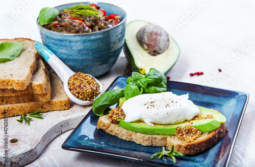 Healthy andwoch with avocado, figs and eggs - sliced avocado and egg on toasted bread with basil and rosemary for healthy breakfast or snack.