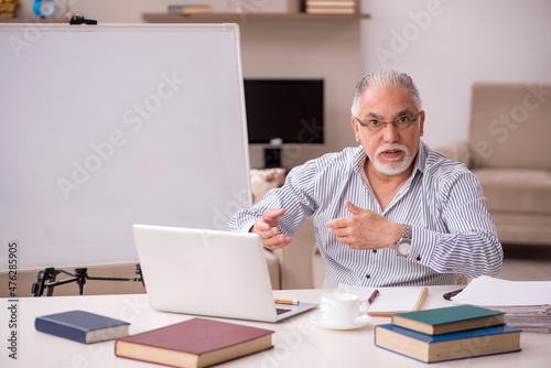 Old male employee working from home during pandemic