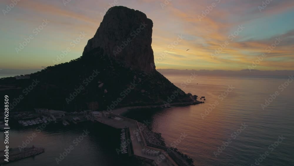Aerial shot, drone point of view Penyal d Ifac Natural Park rocky cliff surrounded by calm Mediterranean Sea water during picturesque sunrise. Province of Alicante, Costa Blanca. Spain. Travel concept