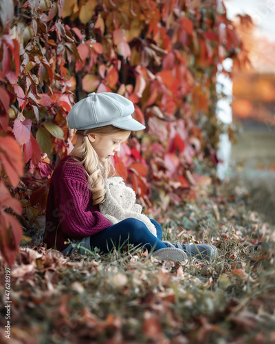 girl sitting with a toy and is sad