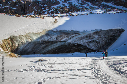 Visitors standing near Oktyabrskaya cave of the Bogdanovich glacier in Kazakhstan photo