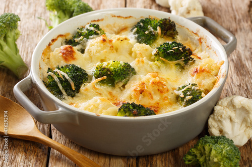 Tableau sur toile Casserole Cauliflower and broccoli baked with cheese sauce in a pot close-up on a wooden table