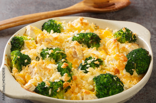 Chicken Divan is a type of chicken and broccoli casserole with a creamy sauce close up in the dish on the old table. Horizontal photo