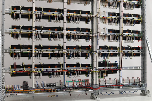 Installation of blocks and modules in an electrical panel with colored electrical wires.