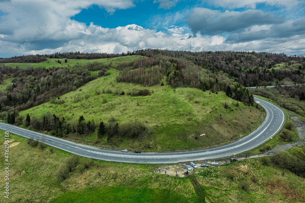 Aerial view of a narrow winding road, through the beautiful wooded Carpathians, amazing spring landscape, outdoor tourist background, Transcarpathia, Ukraine Aerial view of a narrow winding road, through the beautiful wooded Carpathians, amazing spring landscape, outdoor tourist background, Transcarpathia, Ukraine