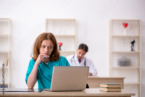 Young male doctor and female assistant working in the clinic