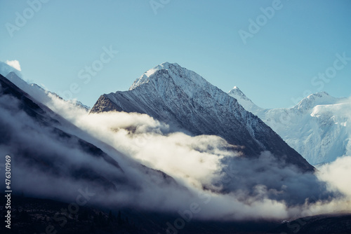 Fotografie, Obraz Beautiful view of snow-capped mountains above thick clouds in sunshine