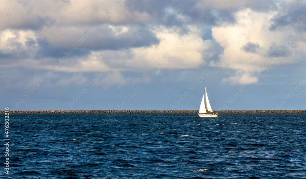 Sailboat sailing in the calm waters of Hilo Bay on Big Island, Hawaii
