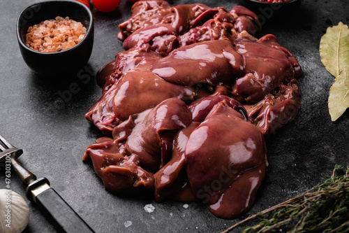 Raw chicken liver, on black dark stone table background