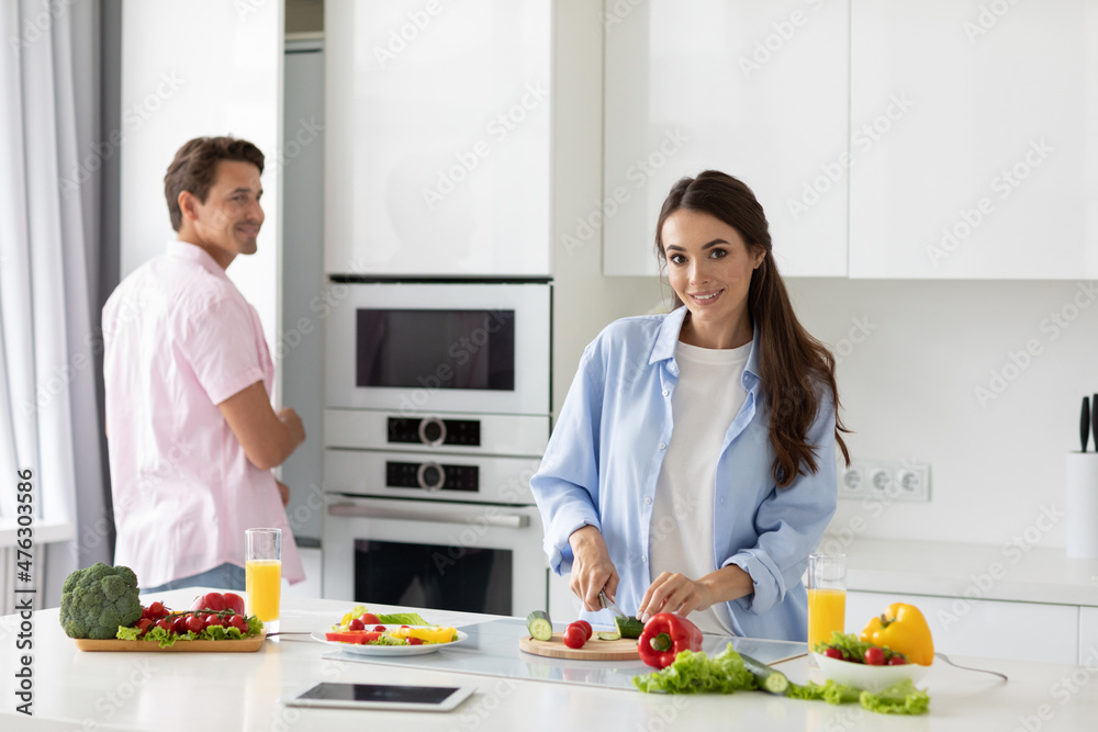 Beautiful young couple cooking in kitchen at home.