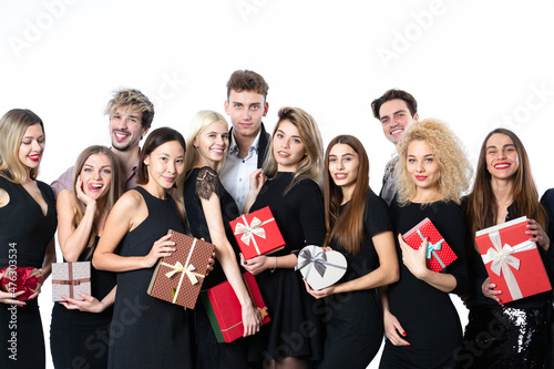 Group portrait of cheerful guests in stylish black clothes for the New Year or birthday. Young people with gifts