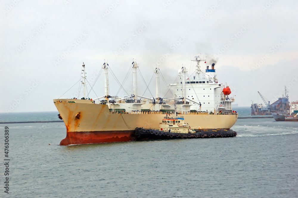 Tugboat assisting bulk cargo ship