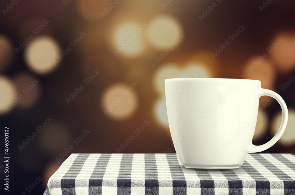 Obraz premium Mug with hot tea standing on a desk with blanket in a cozy room