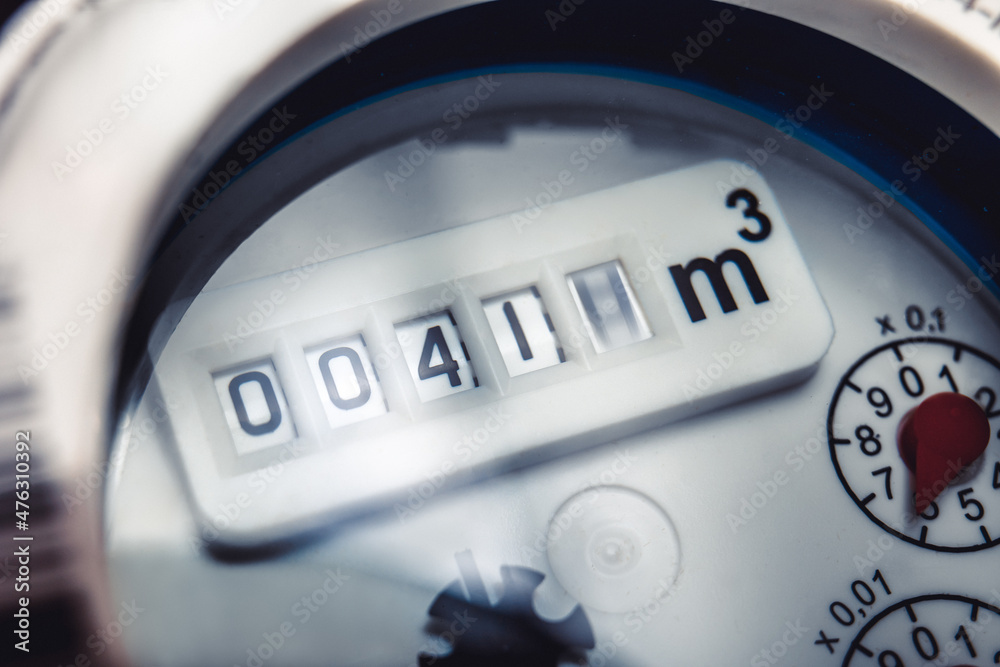 Close up of water meter with rotating digit.