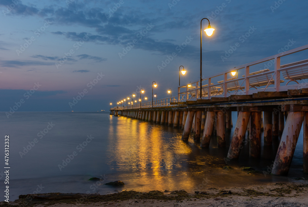 Obraz premium Baltic sea coast, night view of pier at Gdynia Orlowa sea resort, Poland.