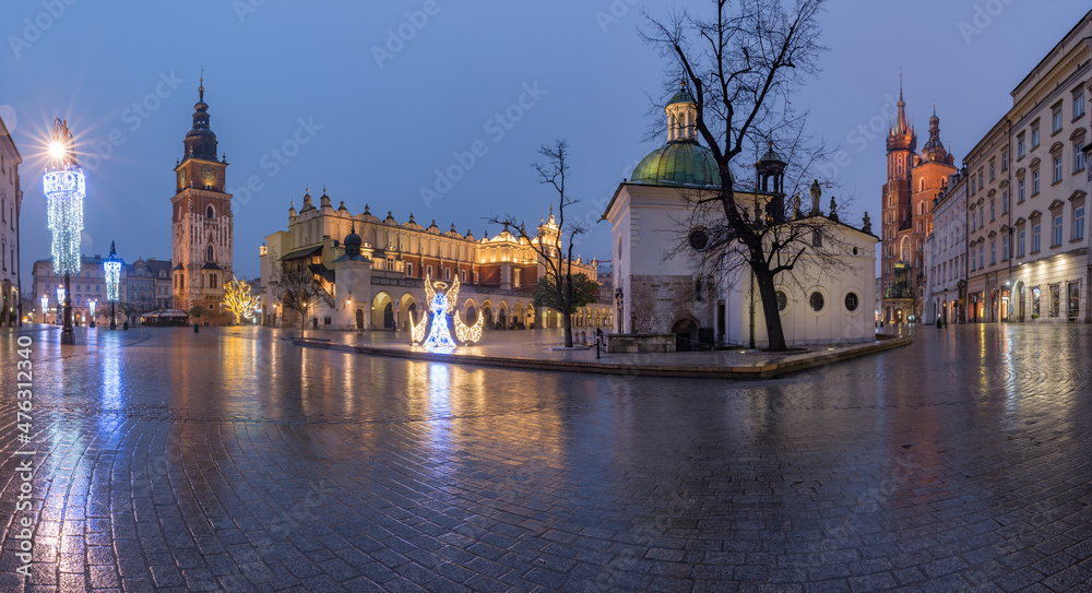 Fototapeta premium Krakow, Poland, main square panorama with Cloth Hall and St Mary's church on wet December morning