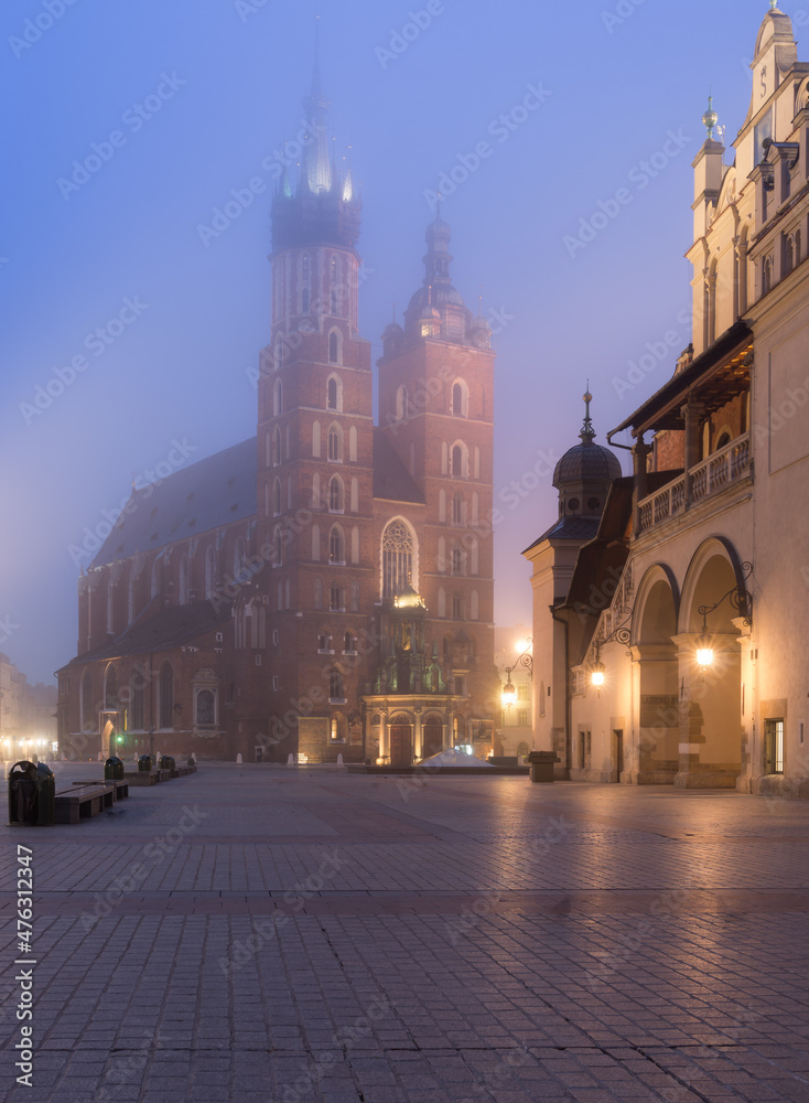 Main market square, Cloth Hall and St Mary's church in the misty night, Krakow, Poland