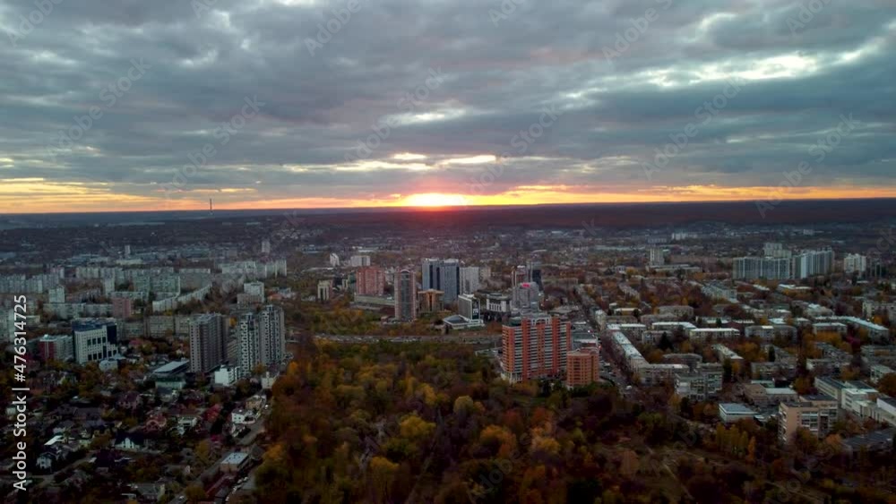 Aerial vivid colorful autumn city park sunset view with epic cloudscape. Botanical garden and Kharkiv city center. Residential district buildings and cars driving Nauky avenue in evening light Aerial vivid colorful autumn city park sunset view with epic cloudscape. Botanical garden and Kharkiv city center. Residential district buildings and cars driving Nauky avenue in evening light