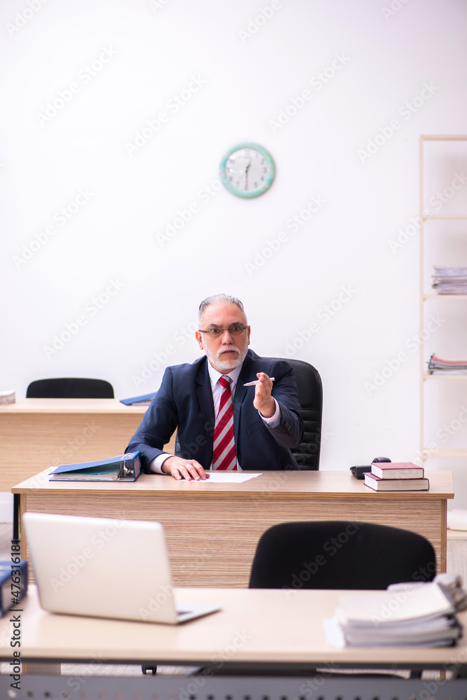 Old businessman employee sitting in the office