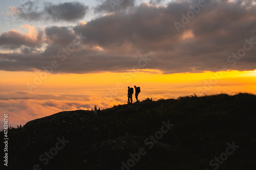 silhouette of People hiking during sunset on top of a mountain