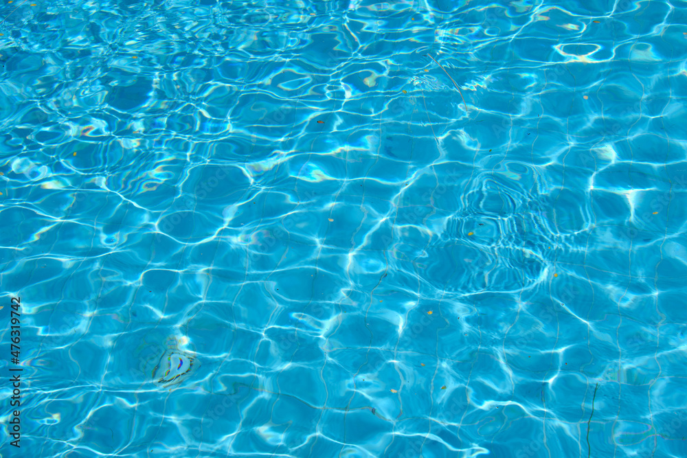 Closeup surface of blue clear water with small ripple waves in swimming pool Closeup surface of blue clear water with small ripple waves in swimming pool