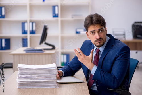 Young businessman employee and too much work in the office