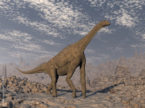 Fototapeta Naklejka Na Ścianę i Meble -  Atlasaurus dinosaur walking in the desert by day - 3D render