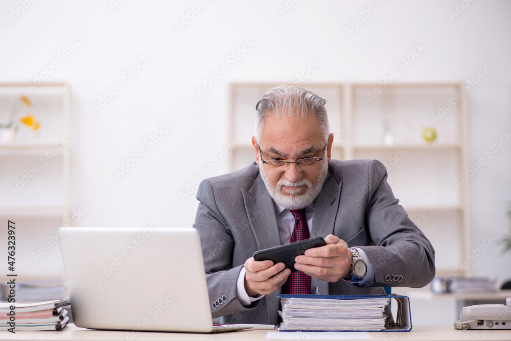 Old male employee working in the office Old male employee working in the office