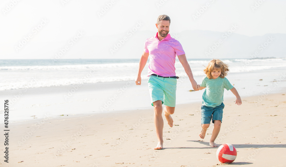 father and son play football on beach. daddy with kid boy on summer day. weekend family day.