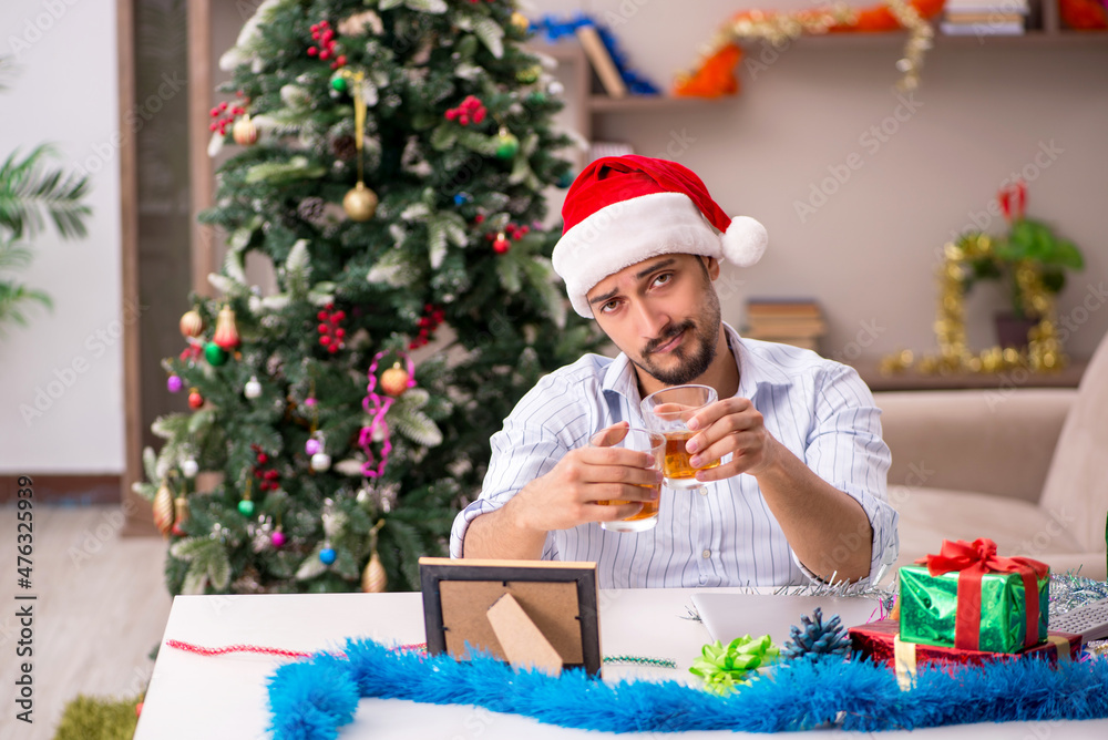 Young man celebrating Christmas at home alone
