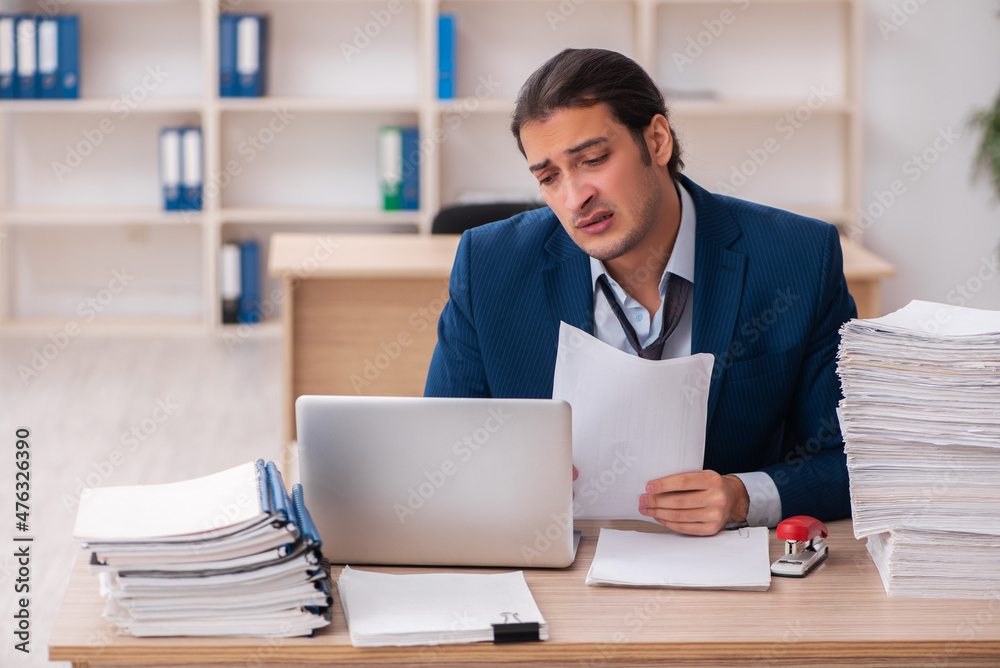 Young male employee unhappy with excessive work Young male employee unhappy with excessive work